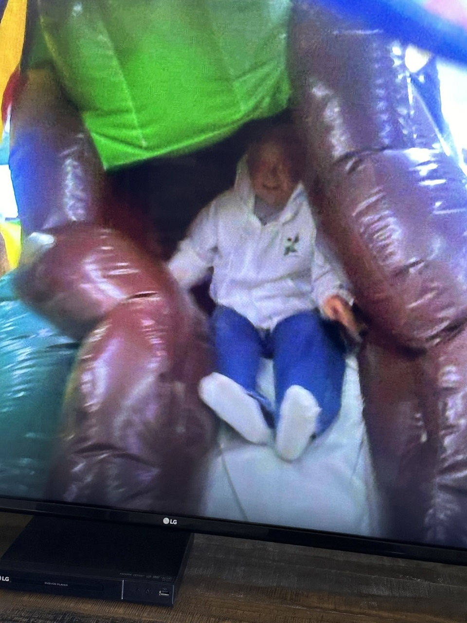 Cardinal teacher Tom Blew sliding down an inflatable slide.