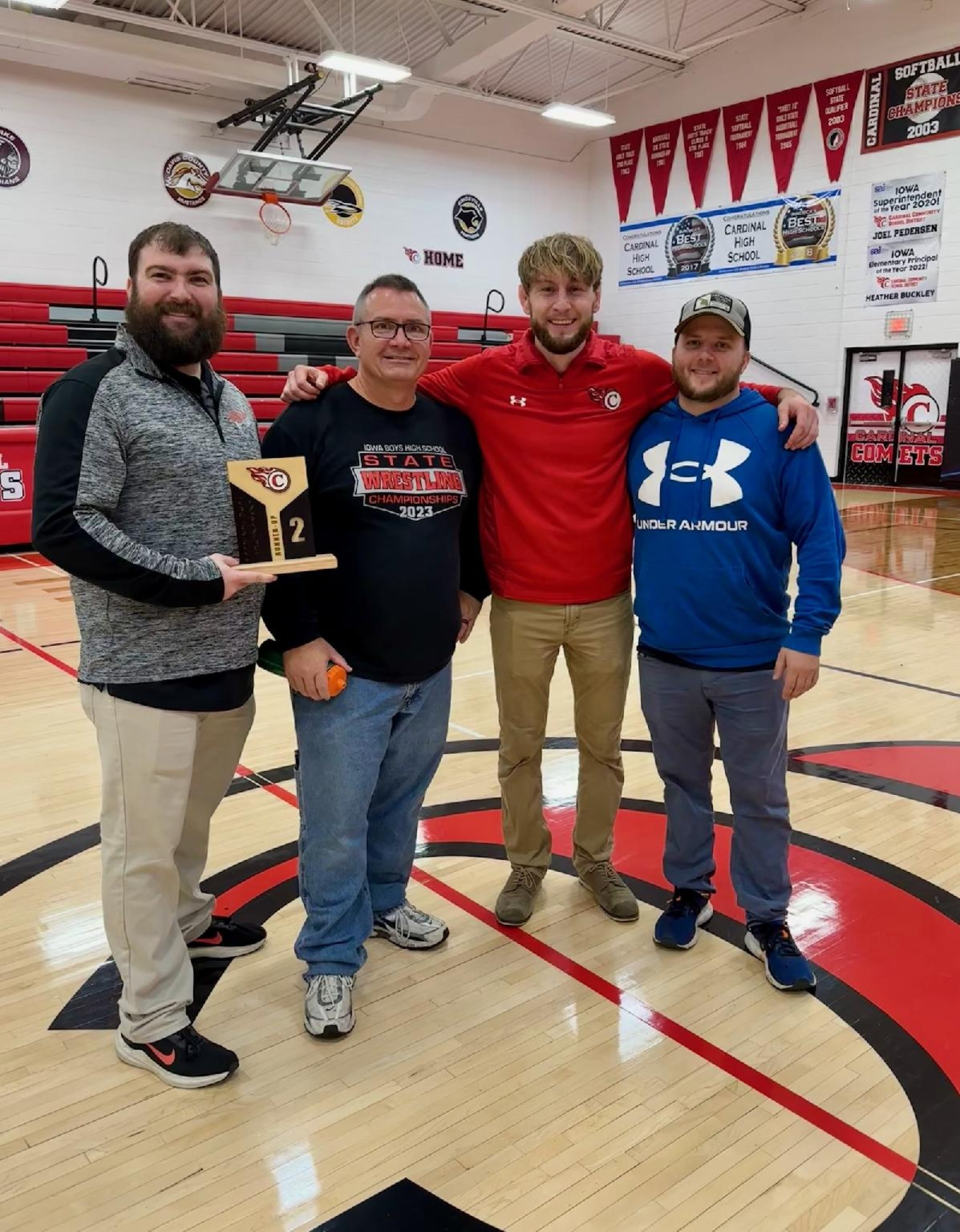 Cardinal Comet wrestling coaches pose with trophy.